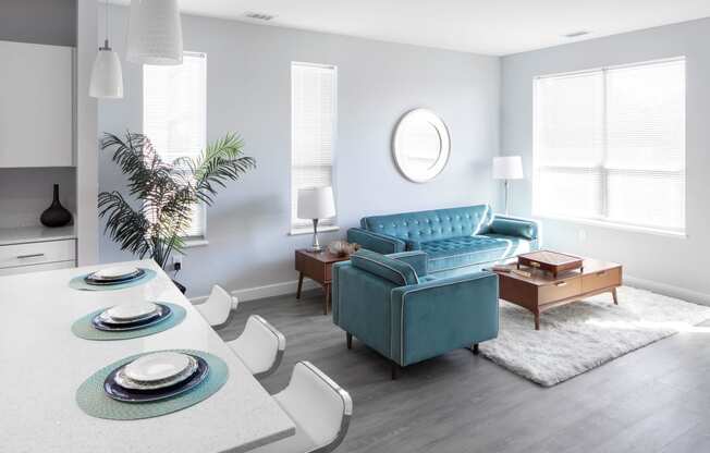 a living room with a blue couch and a table and chairs