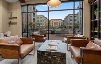 a lounge area with couches and a table in front of a window