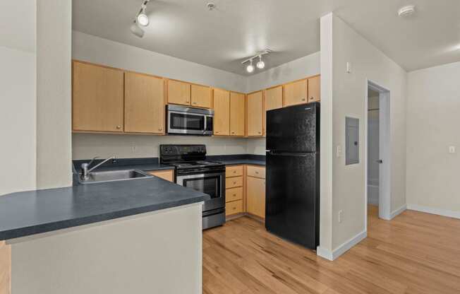 a kitchen with black appliances and wooden cabinets