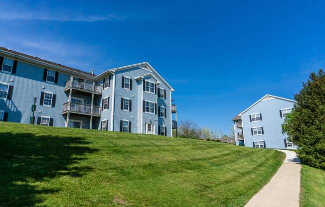 Sidewalk and apartment building on hill with view. Apartments for rent in Kalamazoo, MI near WMU Western Michigan University