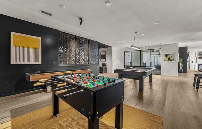 a game room with two pool tables and a billiards table