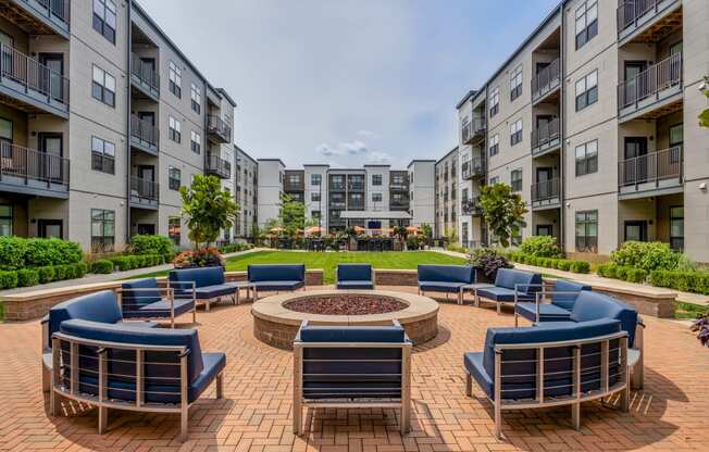 an outdoor lounge area with a fire pit at an apartment complex