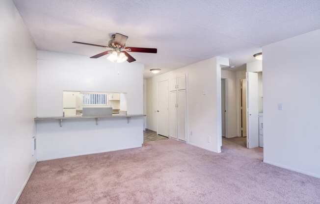 a living room with carpet and a ceiling fan