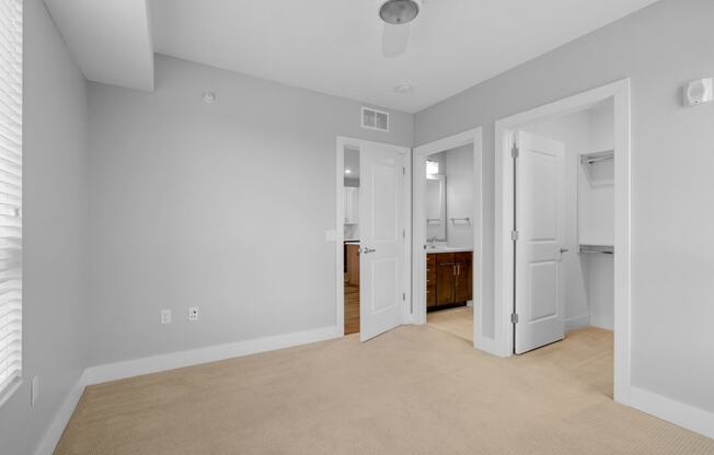 a living room with white walls and a door to a bathroom