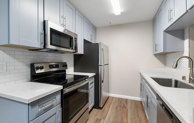 a kitchen with a stove a sink and a microwave
