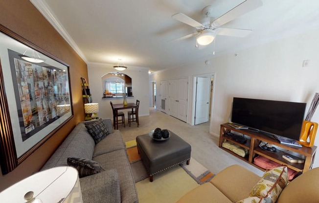 Living room with ceiling fan; opening to kitchen