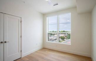 A room with a door and a window overlooking a street.