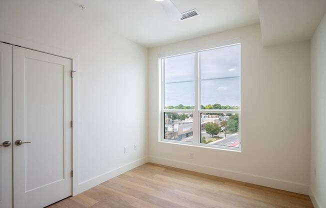 A room with a door and a window overlooking a street.