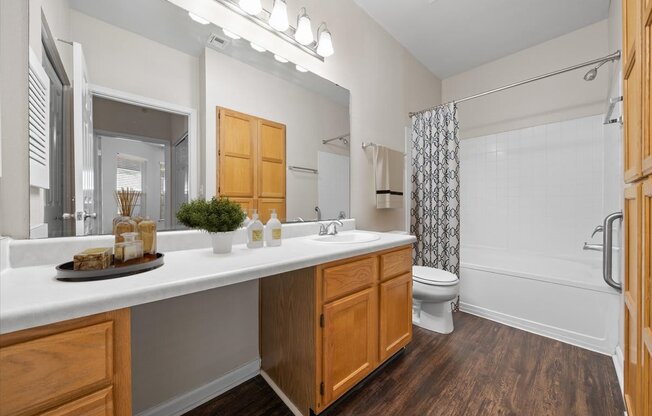 A bathroom with a white countertop and wooden cabinets. at Somerset Oaks Apartment Homes, Olathe, Kansas