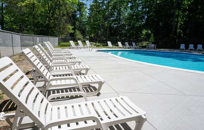 Swimming pool and pool chairs at Woodcrest Apartments in Westland, Michigan