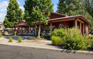 the front of a red building with trees and a street