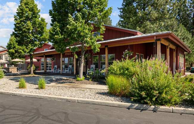 the front of a red building with trees and a street