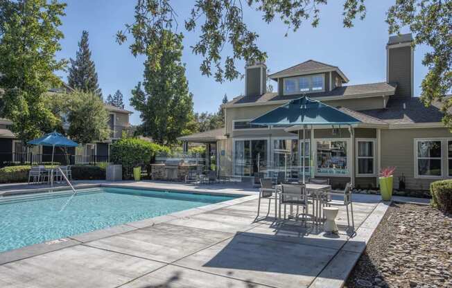 Swimming Pool Area With Shaded Table And Chairs at Atwood Apartments, Citrus Heights, CA