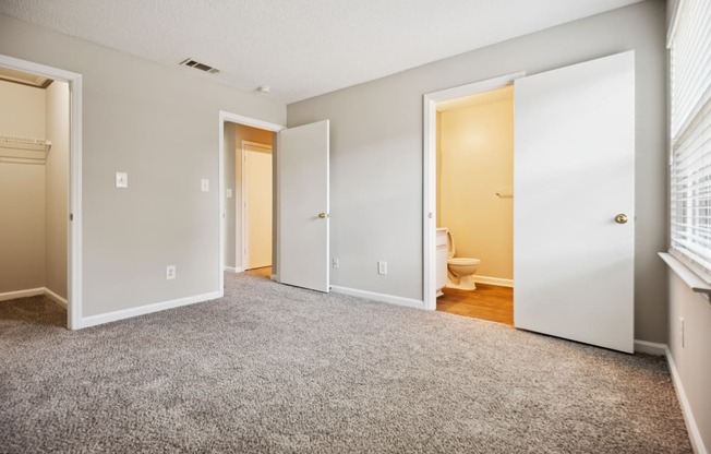 a bedroom with two doors and a toilet