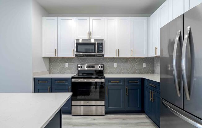 a kitchen with blue and white cabinets and stainless steel appliances