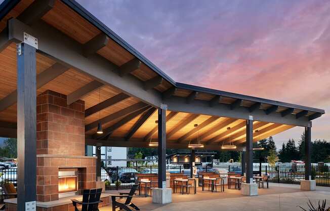 a patio with a fireplace and tables and chairs