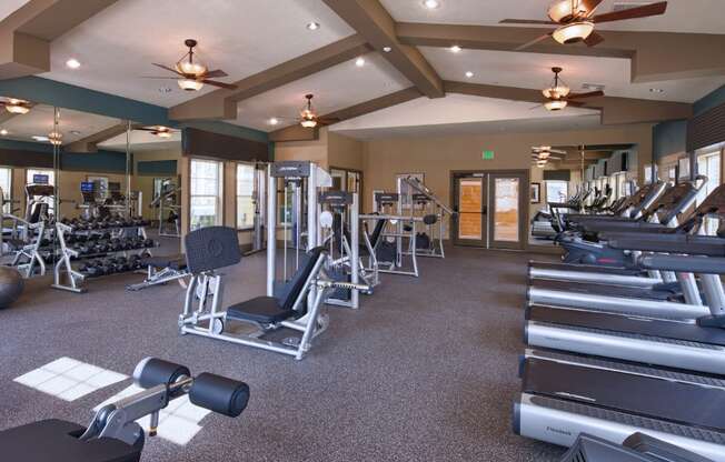 A spacious gym with a variety of equipment including treadmills, weights, and exercise machines.