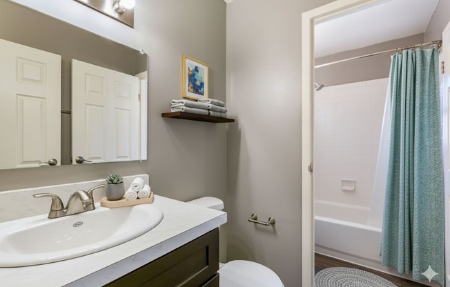 A bathroom with a white sink and a white toilet.