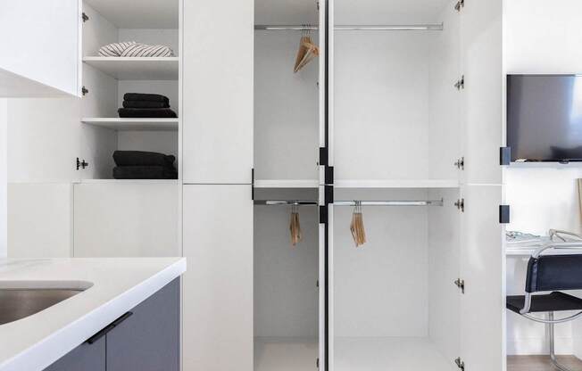 A white and black bathroom with a white sink and a white and black chair at Skylar At Sunset Apartments, Los Angeles 90027
