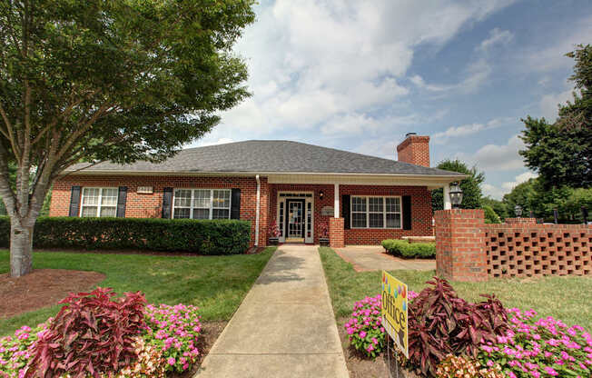 A house with a brick chimney and a sign in front.