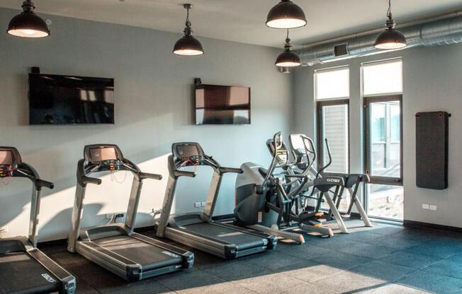 a gym with cardio equipment and a tv on the wall at Barrington 101, Illinois, 60010