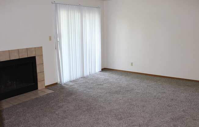 an empty living room with a fireplace