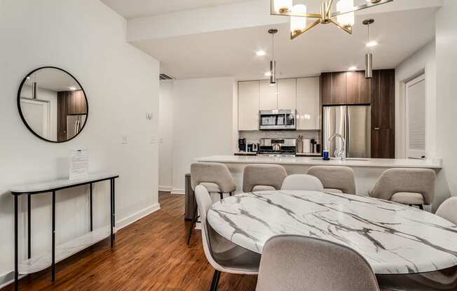 A modern kitchen with a marble table and chairs.
