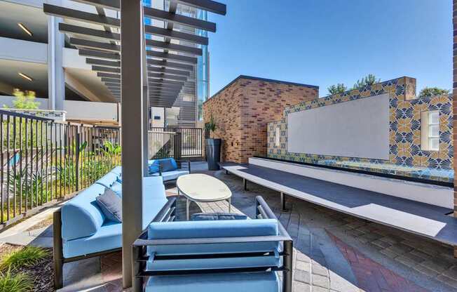 A patio with a blue couch and a table.