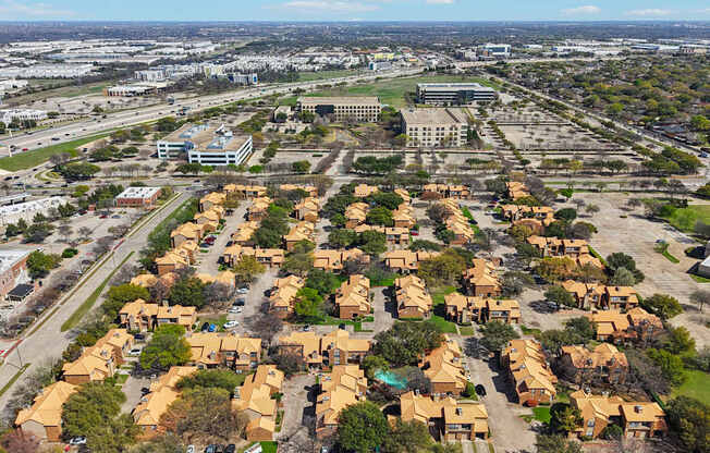 A suburban neighborhood with houses and a large building in the background.