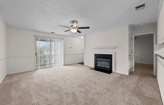 living room with fireplace , ceiling fan, and large patio window at Rosewood at Colony Square, Rocky Mount, NC