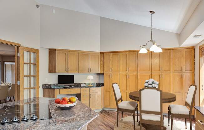 a kitchen and dining room with wooden cabinets and a granite counter top