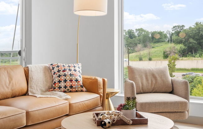 a living room with couches and a coffee table and a large window at The Mera, Minnesota 55426