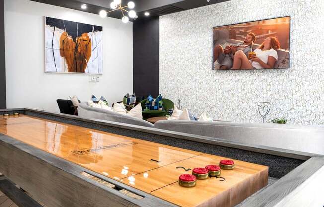A shiny wooden table with four red objects on it.