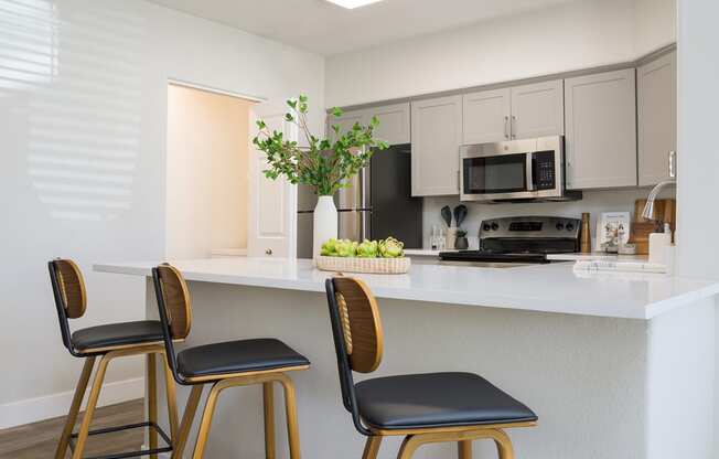 a kitchen with a counter top and three bar stools