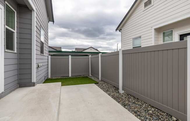 the yard of a home with a white fence and grass