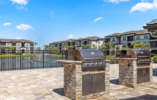 Two stone BBQs in front of apartment buildings.