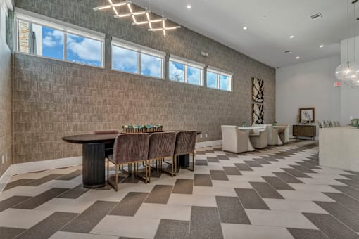 A room with a checkered floor and a long table with chairs.