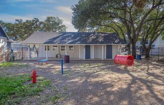 a group of people standing around a fire hydrant in front of a house