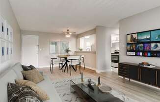 a living room with a couch and a coffee table in front of a dining area