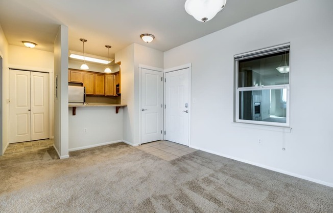 a bedroom with a large window and a door leading to a kitchen