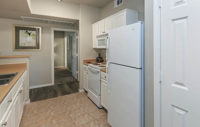 Kitchen with white appliances at The Covington by Picerne, Nevada, 89139