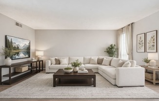 A living room with a white couch, a coffee table, and a painting on the wall.