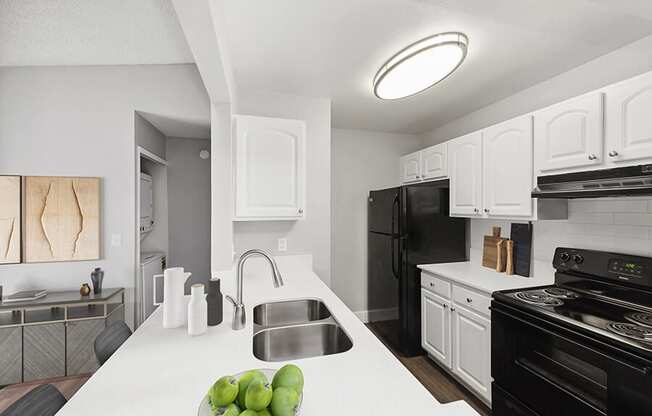 Model Kitchen with White Cabinets and Wood-Style Flooring at Vue at Baymeadows Apartments in Jacksonville, FL.