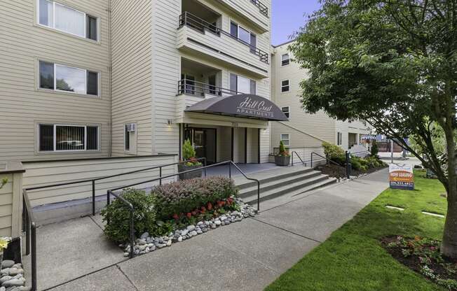 a view of the front of the building with the steps leading up to the entrance at Hill Crest Apartment Homes, WA 98126