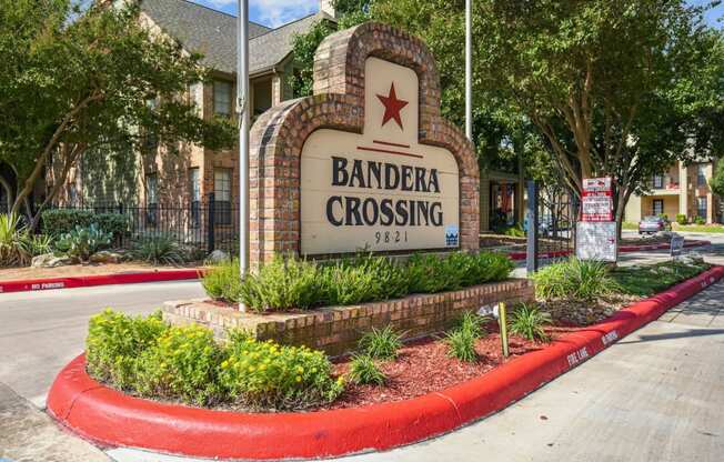 Welcoming entrance sign at Bandera Crossing apartments in San Antonio, TX