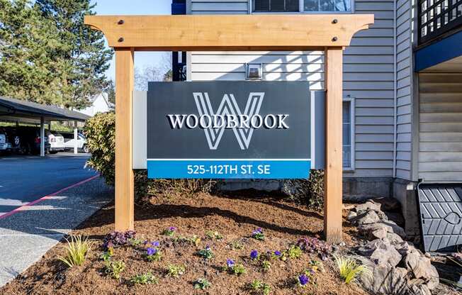 a wooden sign in front of a house