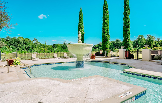 A pool with a fountain in the middle of it.