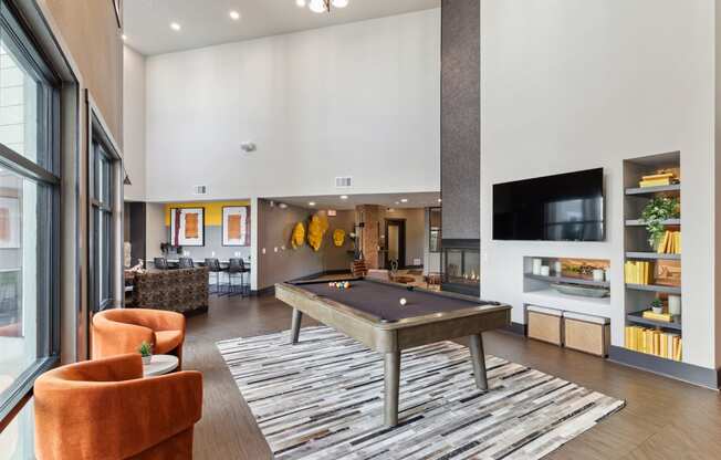 a spacious living room with a pool table and a tv