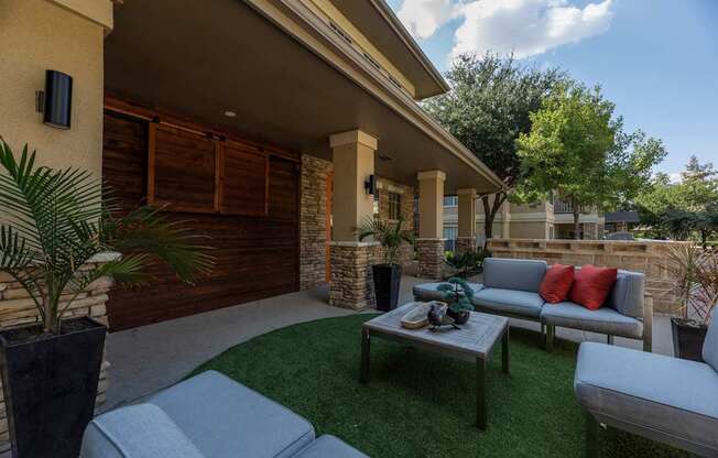 Patio with a grey couch at Woodbridge Villas Apartments, Sachse, TX, 75048