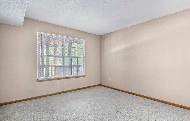 an empty bedroom with a large window